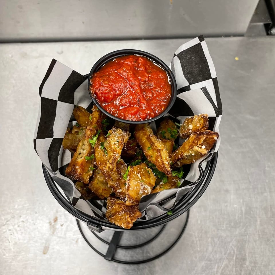 Crispy fried zucchini fries with parmesan and parsley, served with a side of marinara sauce.