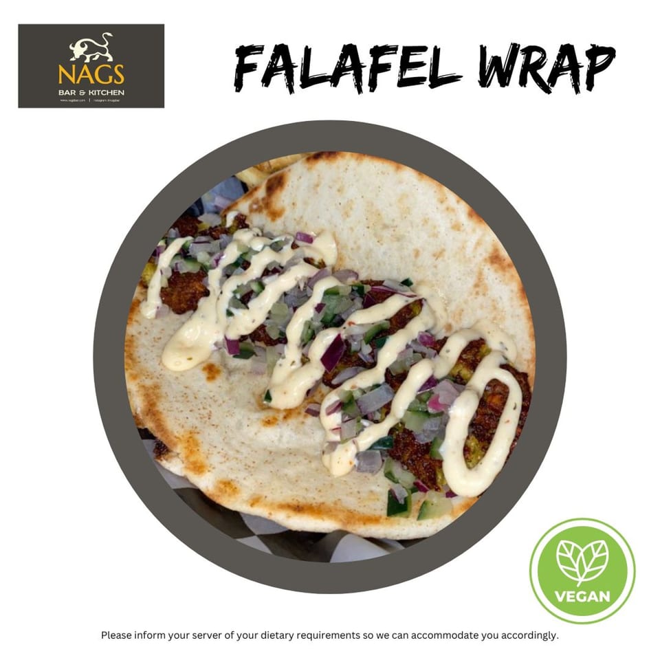 A close-up of a Falafel Wrap from NAGS Bar and Kitchen, topped with sauce, red onions, and cucumbers.